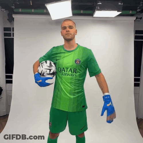 A Man In A Green Qatar Airways Shirt Holds A Ball GIF