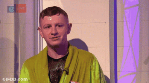A Man In A Green Robe Is Standing In Front Of A Bbc Logo GIF