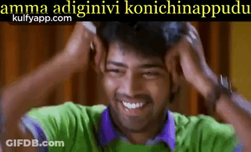 A Man In A Green Shirt And Purple Shirt Is Smiling And Holding His Head . GIF