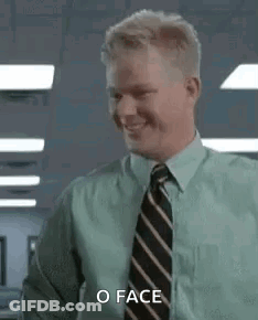 A Man In A Green Shirt And Tie Is Smiling And Saying `` O Face '' . GIF