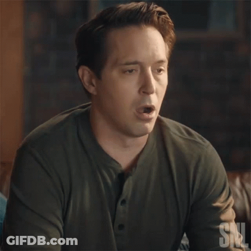 A Man In A Green Shirt Is Blowing A Bubble With A Snl Logo In The Corner GIF