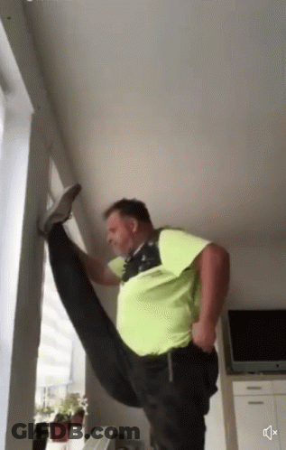 A Man In A Green Shirt Is Doing A Split GIF