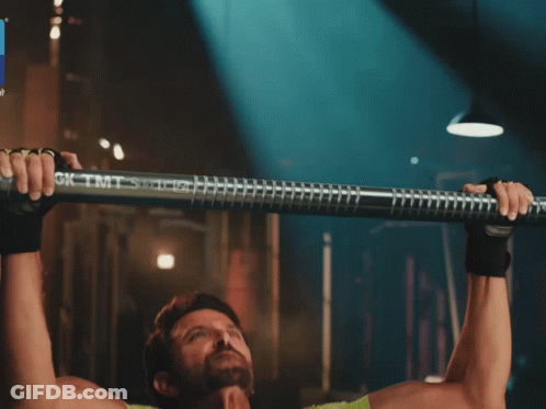 A Man In A Green Shirt Is Doing Pull Ups With A Bar That Says Gk Tmt On It GIF