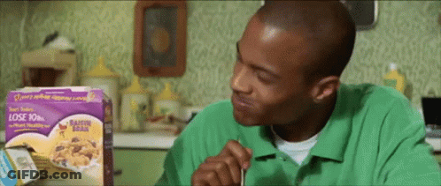 A Man In A Green Shirt Is Eating Raisin Bran GIF