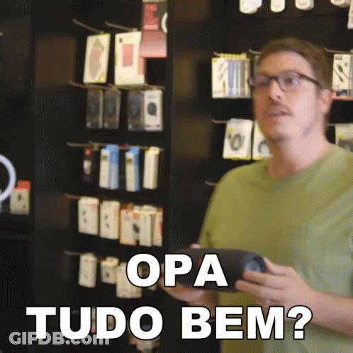 A Man In A Green Shirt Is Holding A Cell Phone And Says " Opa Tudo Bem " In White Letters GIF