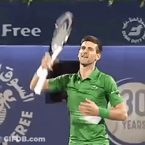 A Man In A Green Shirt Is Holding A Tennis Racquet GIF