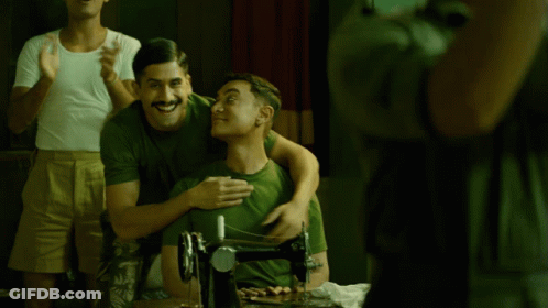 A Man In A Green Shirt Is Hugging Another Man In A White Shirt GIF