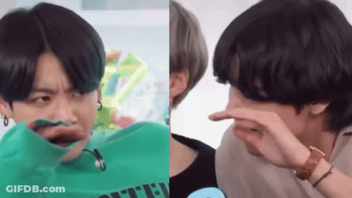 A Man In A Green Shirt Is Making A Funny Face And A Man In A Black Shirt Is Covering His Nose . GIF