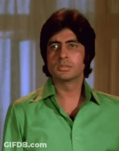 A Man In A Green Shirt Is Making A Funny Face . GIF