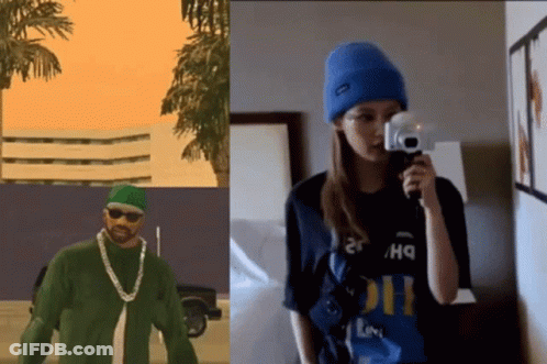 A Man In A Green Shirt Is Next To A Woman Holding A Camera GIF