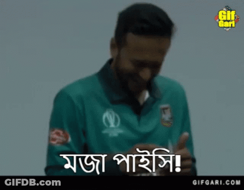A Man In A Green Shirt Is Smiling While Holding A Card In His Hand . GIF