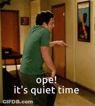 A Man In A Green Shirt Is Standing In A Hallway With The Words Ope It 'S Quiet Time Written On The Bottom GIF