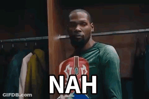 A Man In A Green Shirt Is Standing In A Locker Room With Clothes Hanging On The Racks And Says Nah . GIF