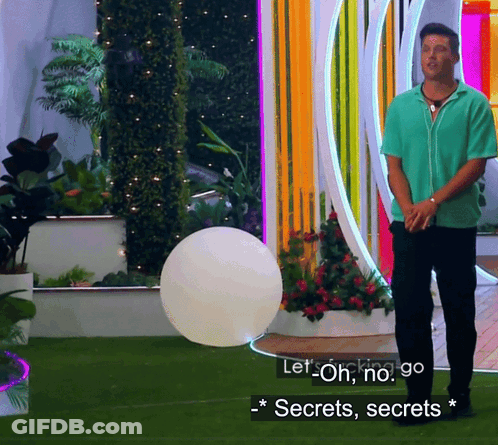 A Man In A Green Shirt Is Standing In Front Of A Colorful Wall And Says Let Oh No Go Secrets Secrets GIF
