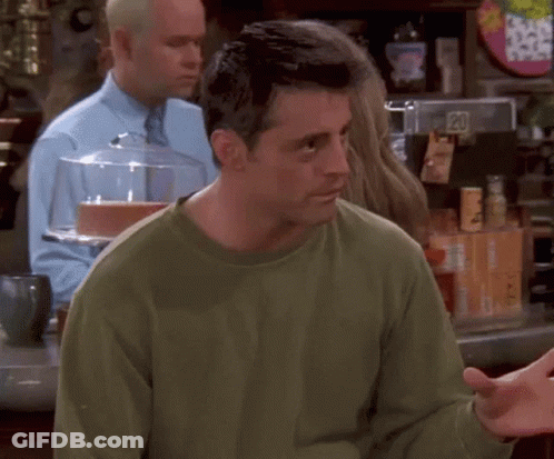 A Man In A Green Shirt Is Standing In Front Of A Counter With A Sign That Says 20 On It . GIF