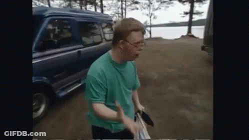 A Man In A Green Shirt Is Standing In Front Of A Van GIF