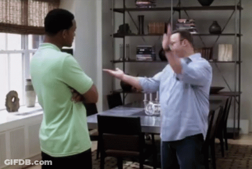 A Man In A Green Shirt Is Standing Next To Another Man In A Blue Shirt GIF