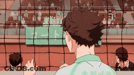 A Man In A Green Shirt Is Standing On A Volleyball Court . GIF