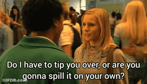 A Man In A Green Shirt Is Talking To A Blonde Woman In A Crowded Hallway GIF