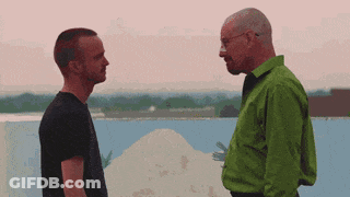 A Man In A Green Shirt Is Talking To A Man In A Black Shirt GIF