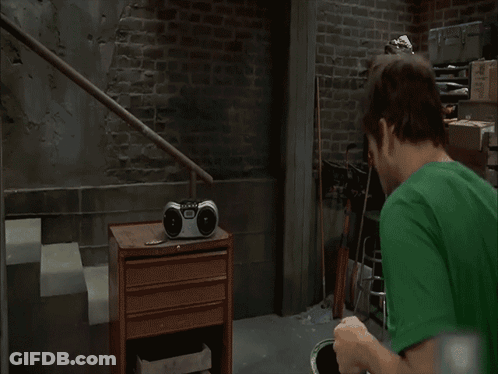 A Man In A Green Shirt Stands In Front Of A Sign That Says " Fly Eagles Fly " GIF