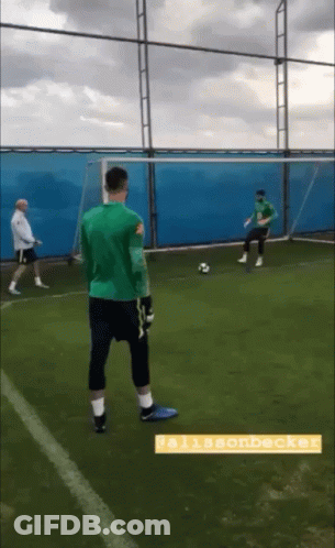 A Man In A Green Shirt Stands On A Soccer Field With The Name Allisonbeck On The Bottom GIF