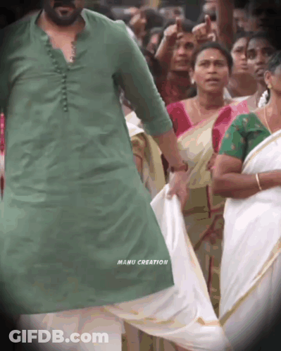 A Man In A Green Shirt With Manu Creation Written On The Bottom Of His Shirt GIF