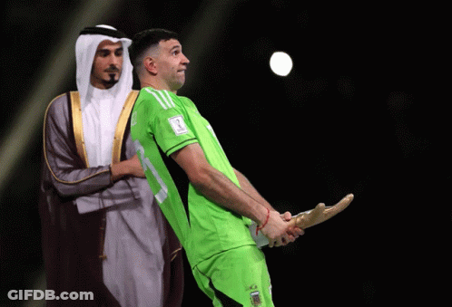 A Man In A Green Shirt With The Number 17 On It Holds A Trophy GIF