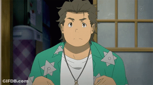 A Man In A Green Shirt With Triangles On It Is Looking At The Camera GIF