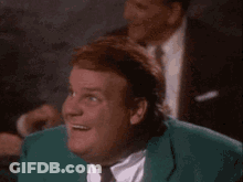 A Man In A Green Suit And Tie Is Smiling While Looking Up . GIF