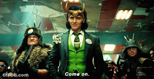 A Man In A Green Suit And Tie Is Standing In Front Of A Group Of People . GIF