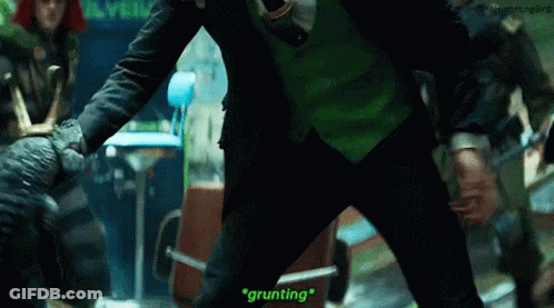 A Man In A Green Suit And Tie Is Standing Next To A Man In A Black Suit And Tie . GIF