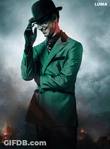 A Man In A Green Suit And Top Hat Is Standing In Front Of A Luma Sign GIF