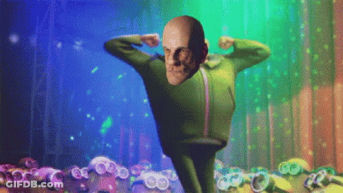 A Man In A Green Suit Is Flexing His Muscles In Front Of Minions GIF