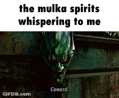 A Man In A Green Suit Is Standing In An Alleyway With The Words " The Mulka Spirits Whispering To Me " Above Him GIF
