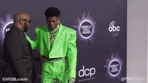A Man In A Green Suit Shakes Hands With A Man In A Black Suit GIF