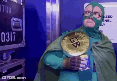 A Man In A Green Superhero Costume Is Holding A Gold Coin That Says Lb GIF