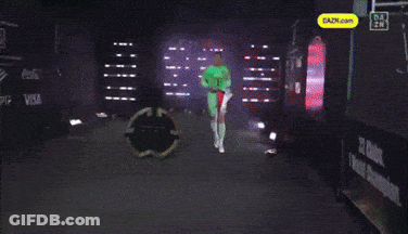 A Man In A Green T Shirt Holds A Red And White Flag GIF