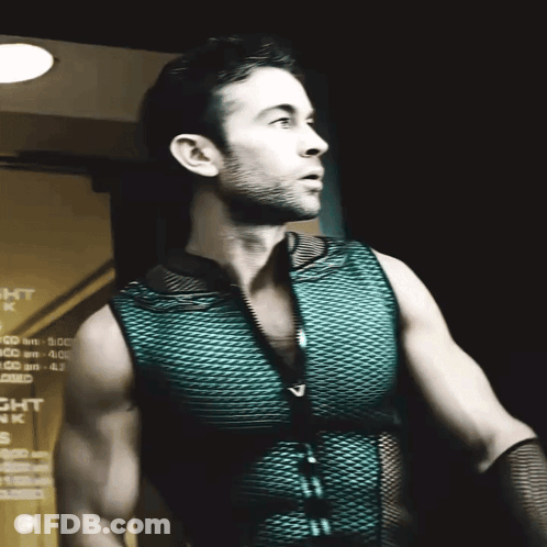 A Man In A Green Vest Stands In Front Of A Sign That Says Night Park GIF