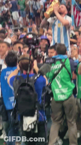 A Man In A Green Vest With The Word Nasty On It Holds A Trophy GIF