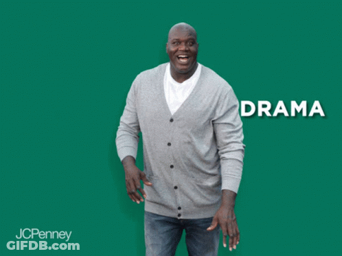 A Man In A Grey Cardigan Is Laughing In Front Of A Green Background With The Word Anxiety GIF