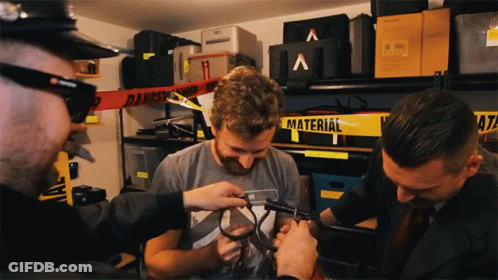 A Man In A Grey Shirt Is Being Measured By A Man In A Black Suit GIF