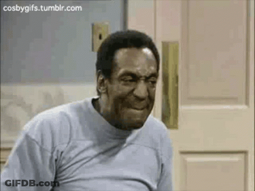A Man In A Grey Shirt Is Making A Funny Face . GIF