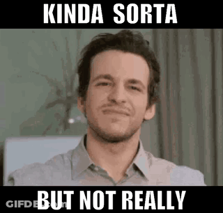 A Man In A Grey Shirt Is Smiling And Making A Funny Face . GIF