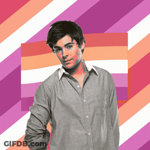A Man In A Grey Shirt Is Standing In Front Of A Pink And White Striped Background GIF