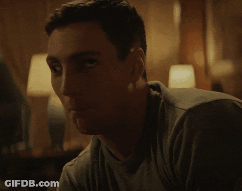 Man In Grey Shirt Looking At Camera GIF