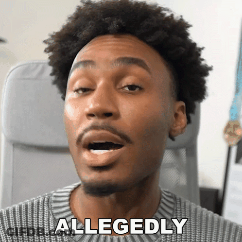 A Man In A Grey Sweater Says Allegedly In Front Of His Face GIF