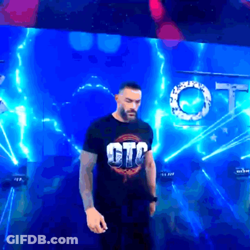 A Man In A Gtc Shirt Stands In Front Of A Blue Background GIF