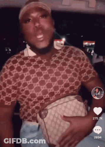 A Man In A Gucci Shirt Is Holding A Purse On His Stomach GIF