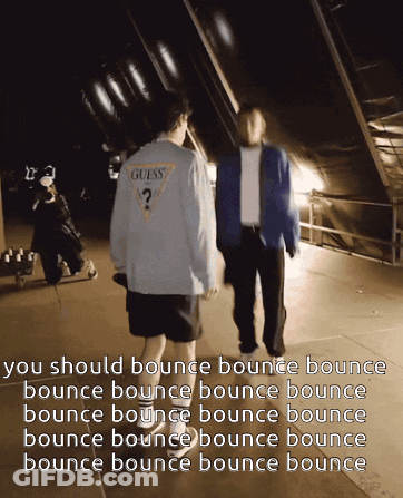 A Man In A Guess Shirt Walks With Another Man In A Blue Jacket GIF